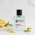 Perfume bottle labeled 'The Decant Perfumery' with a lemon and flowers on a light background